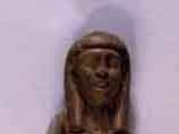 A dark, slender wooden statue of an ancient Egyptian female servant after conservation treatment.